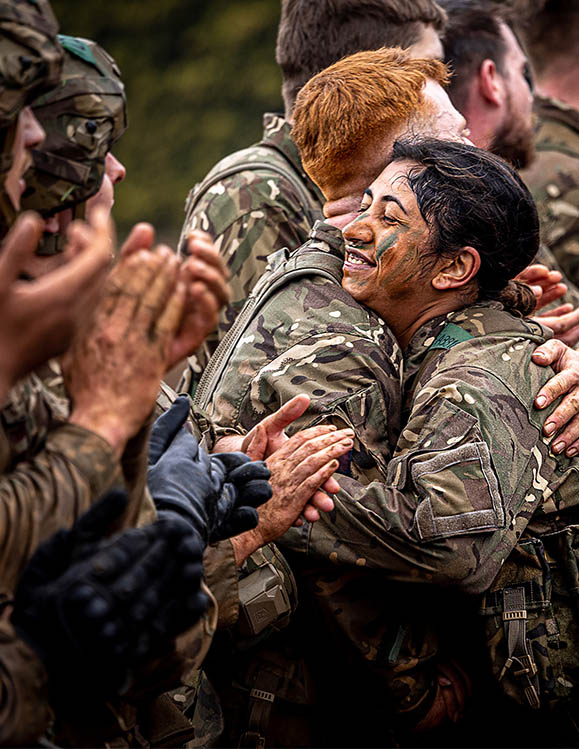 RAF Recruits in camouflage celebrate after completing Cat A test, others clapping