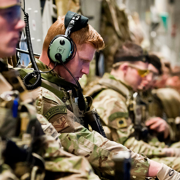 RAF Regiment Gunners seated in transport aircraft wearing comms headset