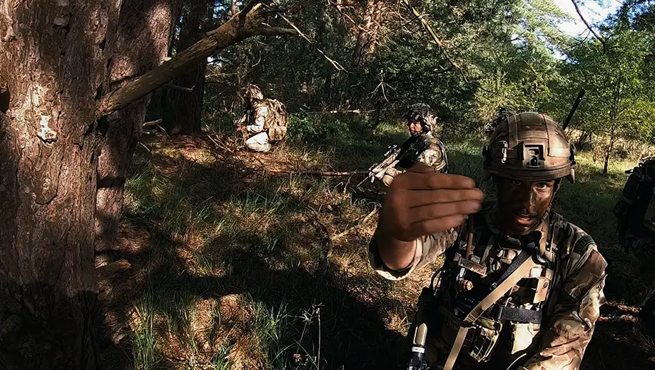 RAF Regiment Gunner on exercise in woodland, beckoning viewer to exit vehicle