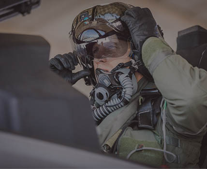 RAF Fast Jet Pilot in cockpit, lowering helmet visor preparing for flight