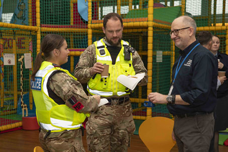 RAF Families Federation rep with two RAF Police at RAF Halton families play area