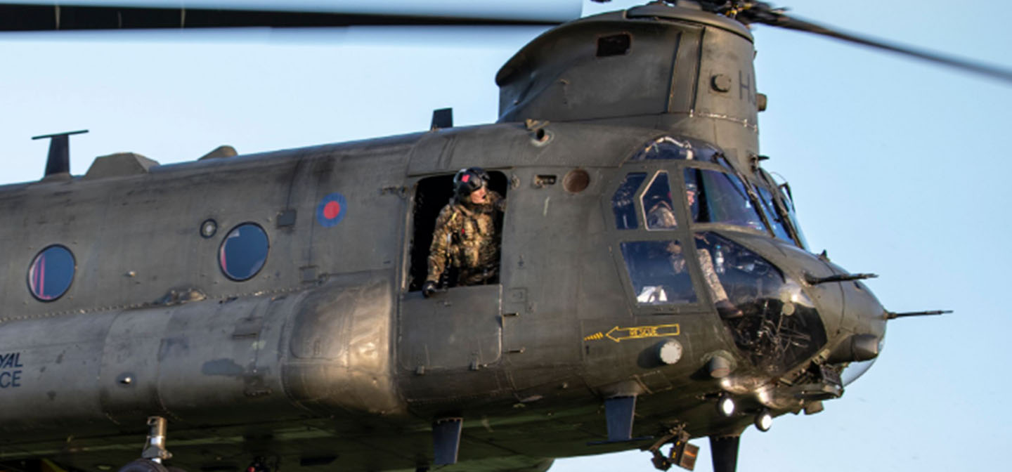 RAF Weapon Systems Operator (Crewman) leaning out of front door of Chinook helicopter