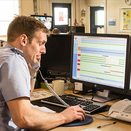 RAF Air Operations Systems Officer using computer while on phone