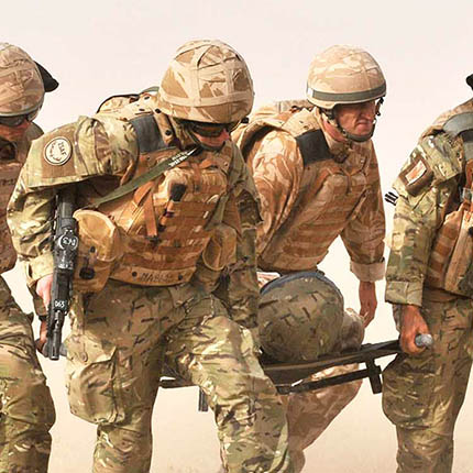 RAF Medics in dust-storm carrying casualty on stretcher as part of MERT