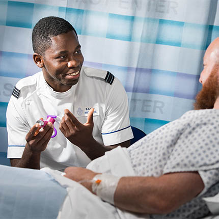 RAF Nursing Officertalking to patient at bedside