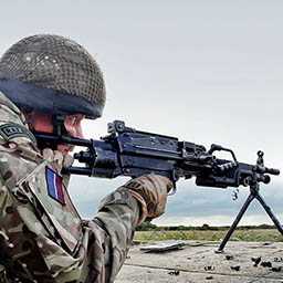 RAF Regiment Gunner firing light machine-gun from concrete wall
