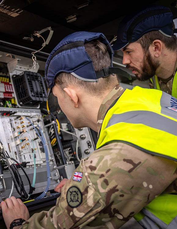 RAF Cyberspace Communications Specialist working on specialist equipment under guidance
