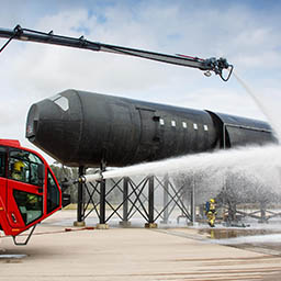 RAF Firefighters spraying foam on burning practice aircraft rig