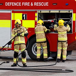 RAF Firefighters prepare to spray foam on burning practice aircraft rig