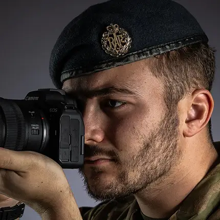 RAF Photographer looking through lens of digital camera in studio