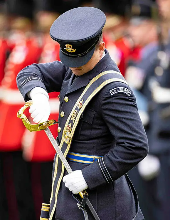 RAF Regiment Officer sheathing sword at ceremonial parade in front of RAF Regiment Gunners and British Army Guardsmen