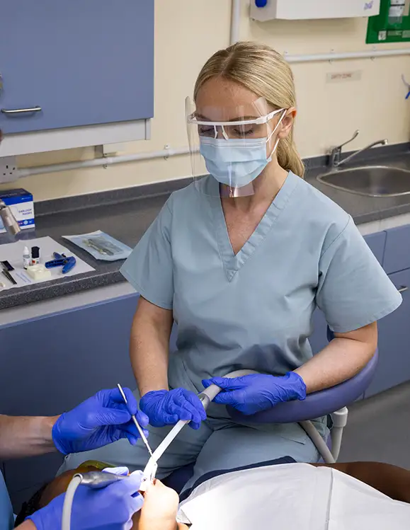 RAF Dental Nurse assisting RAF Dental Officer to treat patient in RAF Dental Surgery