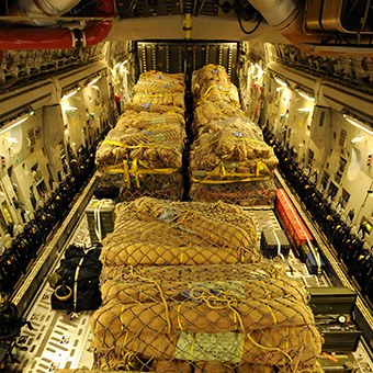 Aid pallets and cargo secured in cargo aircraft hold