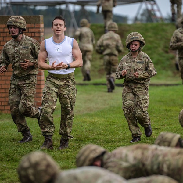 RAF Physical Training Instructor with trainees on assault course