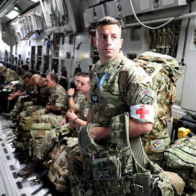RAF Sergeant Medic in camouflage in cargo aircraft deploying on a mission